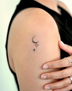 a woman's arm with a small tattoo on the left side of her shoulder