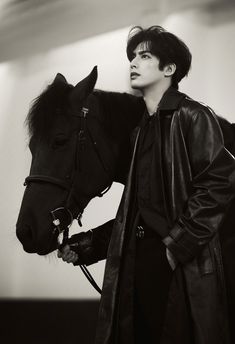 black and white photograph of a woman standing next to a horse