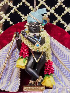 a statue is adorned with flowers and beads