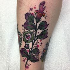 a close up of a person's leg with a flower on it and an eye in the middle