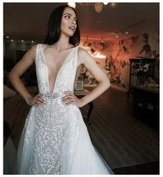 a woman in a white dress posing for the camera