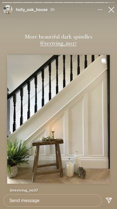 a wooden table sitting under a stair case next to a bannister and potted plant