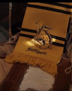 an old harry potter scarf with hogwart's crest on it and some scissors next to it