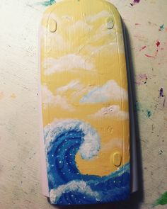 a painted surfboard sitting on top of a table