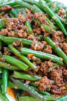 a white plate topped with green beans and meat