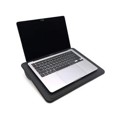 an open laptop computer sitting on top of a black stand with its lid closed and keyboard missing