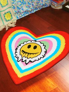 a heart shaped rug with a smiley face on it