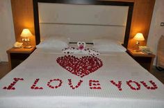 a bed decorated with red hearts and the words i love you spelled out on it