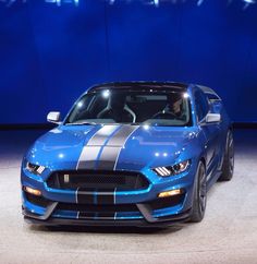 a blue sports car on display at an auto show