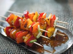 several skewers of food on a metal plate