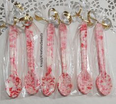 four pink and white candy spoons in plastic bags