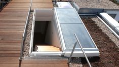 the stairs lead up to an open door on top of a roof that's covered in gravel and wood