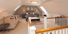 an attic bedroom with two couches and a bed in the corner on the second floor