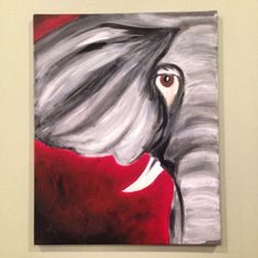 an elephant painting hanging on the wall in front of a white frame with a red background