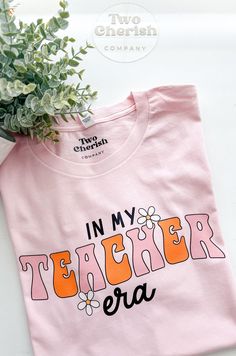 This Listing is for 1 - In my Teacher Era T-Shirt Such a cute T-Shirt to gift to your favorite Teacher, or buy one for yourself. Super Comfy Shirt is 100% cotton Bella & Canva Brand  **If you have any other color in mind that you would like, send us a message. Care Instructions: -Turn inside out and machine wash cold -Hang dry or tumble dry on low heat -Do not iron on design -Do not bleach **Keep in mind that monitors have different color settings, so the color of the product may differ slightly School Spirit Graphic Print Tops For Spring, Spring Graphic Print Top For School Spirit, Funny Pink T-shirt With Text Print, Cute Spring T-shirt With Funny Text, Cute Pink T-shirt With Text Print, Spring School T-shirt With Slogan, Fun Pink Shirt With Funny Text, Spring Slogan T-shirt For School, Cute Text Print Tops For School