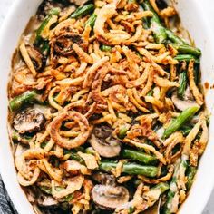 a casserole dish with mushrooms, green beans and onions in it on a white plate