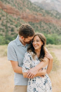 a man and woman hugging each other in the desert