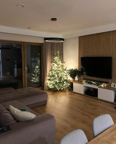 a living room filled with furniture and a christmas tree in the middle of the room