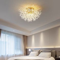 a bedroom with a large bed and a chandelier hanging from the ceiling above it