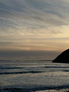 the sun is setting over the ocean and mountains