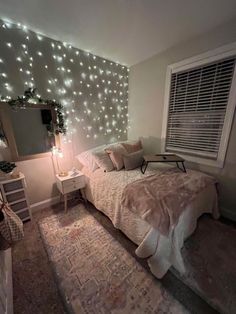 a bed room with a neatly made bed and lights on the wall