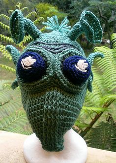 a green knitted hat with eyes and ears