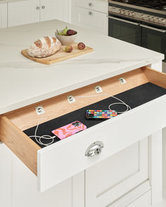 an open drawer in the middle of a kitchen counter with some food on top of it