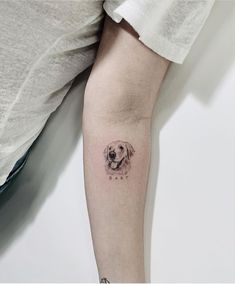 a small dog tattoo on the left arm