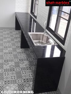 a kitchen with black and white tile flooring next to a sink in front of a window