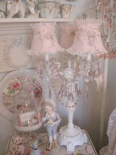 a white table topped with lots of pink lamps