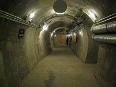 an underground tunnel with pipes and lights