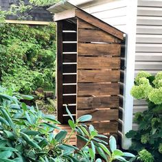 a wooden outhouse sitting in the middle of a garden