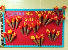 a bulletin board with flowers on it that says leaders are going for gold