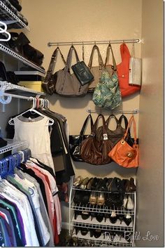 an organized closet with handbags and purses hanging on the wall next to shoes