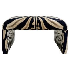 a zebra print bench with black and white stripes on it's legs, sitting in front of a white background