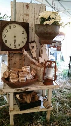 an old clock sitting on top of a table next to some baskets and other items