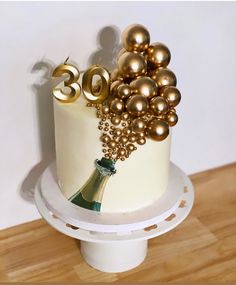 a birthday cake decorated with gold balloons and the number twenty five on it's side