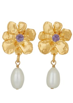 The Flower Pearl Drop Earrings are a set of gold plated or white bronze plated flowers dripping with a single pearl. Featuring either a violet, red, or green glass stone at the flower center, these earrings serve as a timeless, elegant adornment. Add to any outfit for a look that sings. Can be dressed up or down. MONDO MONDO brings us collections of handcrafted, mythologically inspired jewelry and a treasure trove of fragrances. Emanating an imitation of the heirloom and the fantasy of a relic,