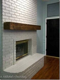 a white brick fireplace in a room with hardwood floors and blue paint on the walls