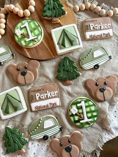 decorated cookies are arranged on a table with white doily and green decorations for the park