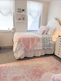 a bed room with a neatly made bed and a rug on the floor in front of a window