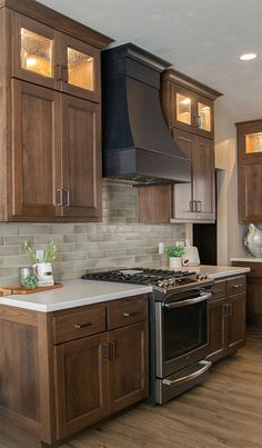 a kitchen with wooden cabinets and stainless steel stove top oven in the center, surrounded by wood flooring