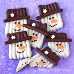 snowmen made out of marshmallows on a purple background with white and brown icing