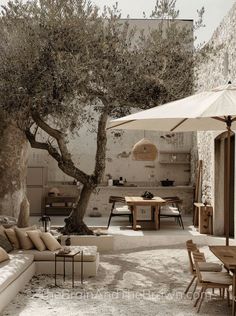 an outdoor living area with tables, chairs and umbrellas on the ground near a tree