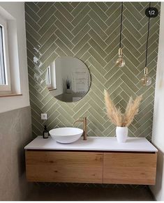 a bathroom with a sink, mirror and vase on the counter next to the window