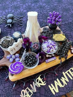 a table topped with lots of halloween decorations and candy on top of a wooden board