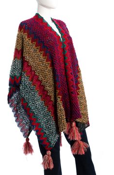 Layer up in this cotton-blend poncho knit with vibrant zigzags and finished with playfully oversized tassels along the hem. 33" length Open front Poncho sleeves 64% cotton, 22% acrylic, 14% nylon Hand wash, line dry Imported Casual Winter Poncho With Tassels, Multicolor Tassel Poncho For Winter, Winter Woven Poncho One Size, Winter Multicolor Poncho With Tassels, Multicolor Fringed Shawl For Winter, Multicolor Fringe Shawl For Winter, Winter Multicolor Fringed Shawl, Red Poncho For Beach In Fall, Fall Multicolor Fringe Shawl