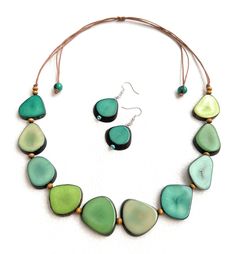 Green Tagua Necklace Set Necklace Length: 34 inches adjustable to shorter length Earrings Length: 1.17 inches About Tagua This Product is handcrafted from a palm tree nut native to the lush tropical rainforests of Ecuador. Also referred to as the Ecuadorean Ivory Palm, the Tagua tree produces several bushels of seed pods a year with up to 100 Tagua nuts per pod. These nuts are then harvested, dried, and crafted into a wide range of products from vibrant modern jewelry, ornate figurines, to every Unique Green Fair Trade Necklace, Green Fair Trade Necklace For Gift, Unique Green Fair Trade Jewelry, Organic Necklace, Eco Friendly Necklace, Tagua Necklace, Tagua Jewelry, Tagua Nuts, Seed Pods