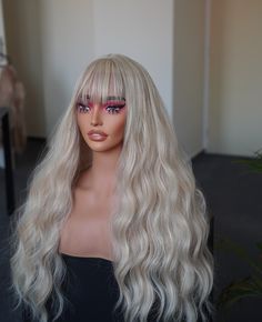 A beautiful long, blonde synthetic wig with bangs is characterized by glossy strands that extend below the shoulders. The vibrant blonde color gives the wig a natural and healthy appearance. The synthetic fibers used in its construction mimic the texture of real human hair, offering versatility in styling with options for straight, wavy, or curly looks. The inclusion of bangs, which can be straight-across, side-swept, or layered, adds a stylish and distinctive element to the overall design.    T Blonde Wavy Wig, Chemo Wig, Wavy Wig With Bangs, Wigs Glueless, Glueless Wig, Wavy Wig, Side Swept, Wig With Bangs, Long Blonde