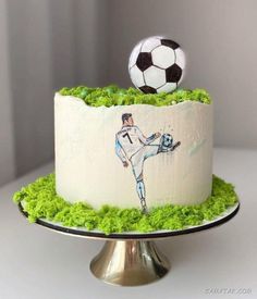 a cake decorated with grass and a soccer ball on top